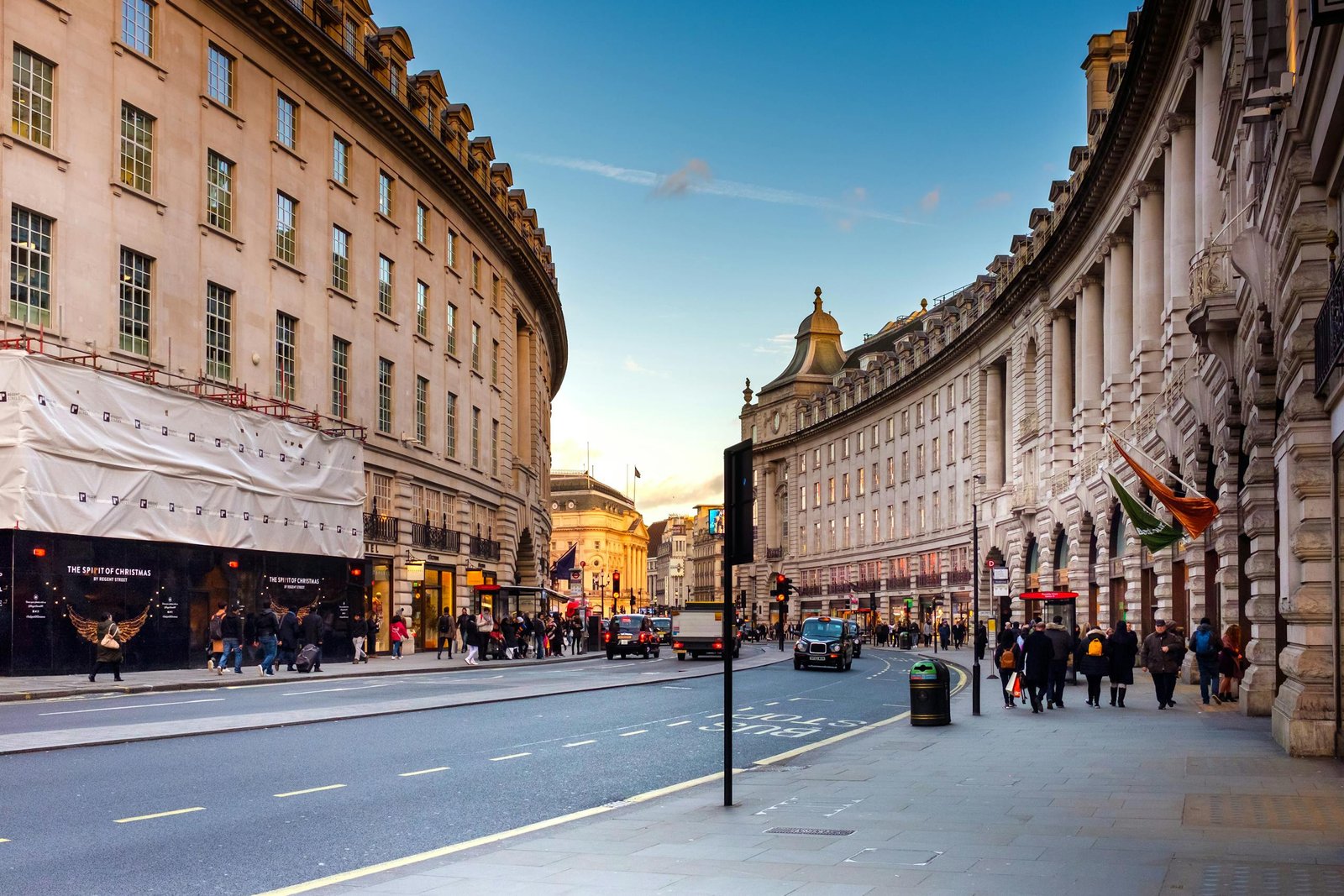 A bustling view of Regent Street in London with historic architecture and lively street life.