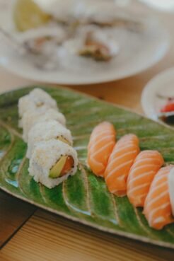 Japan Travel Guide: Everything You Need to Know for an Unforgettable Trip 9 A vibrant sushi platter featuring sushi rolls and salmon nigiri on a green leaf plate.
