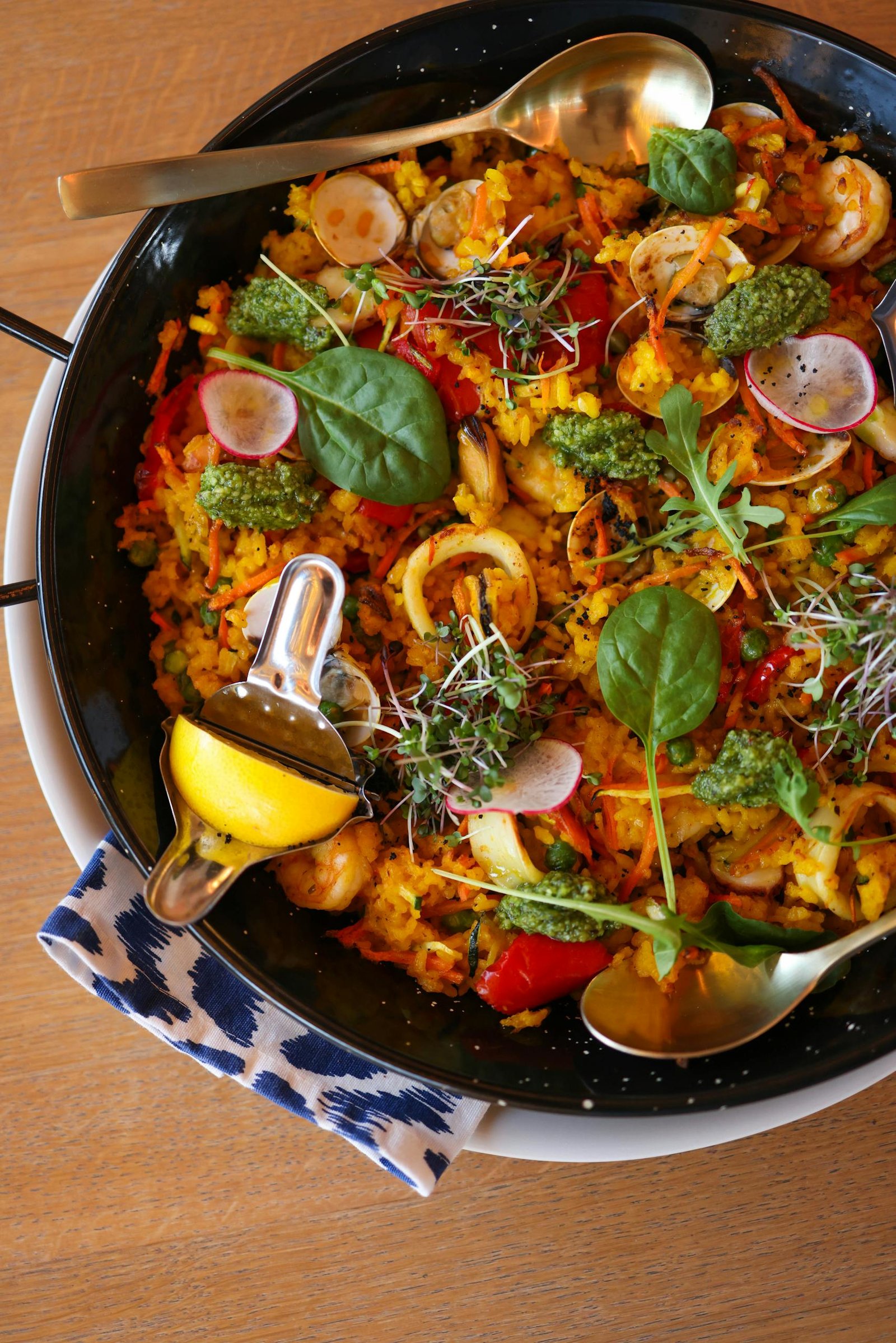 Spain Travel Guide: Things to know before travelling to Spain 10 Close-up of vibrant seafood paella with fresh garnishes and lemon squeezer.