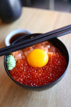 Japan Travel Guide: Everything You Need to Know for an Unforgettable Trip 12 Close-up view of a salmon roe and egg donburi dish garnished with wasabi and soy sauce.