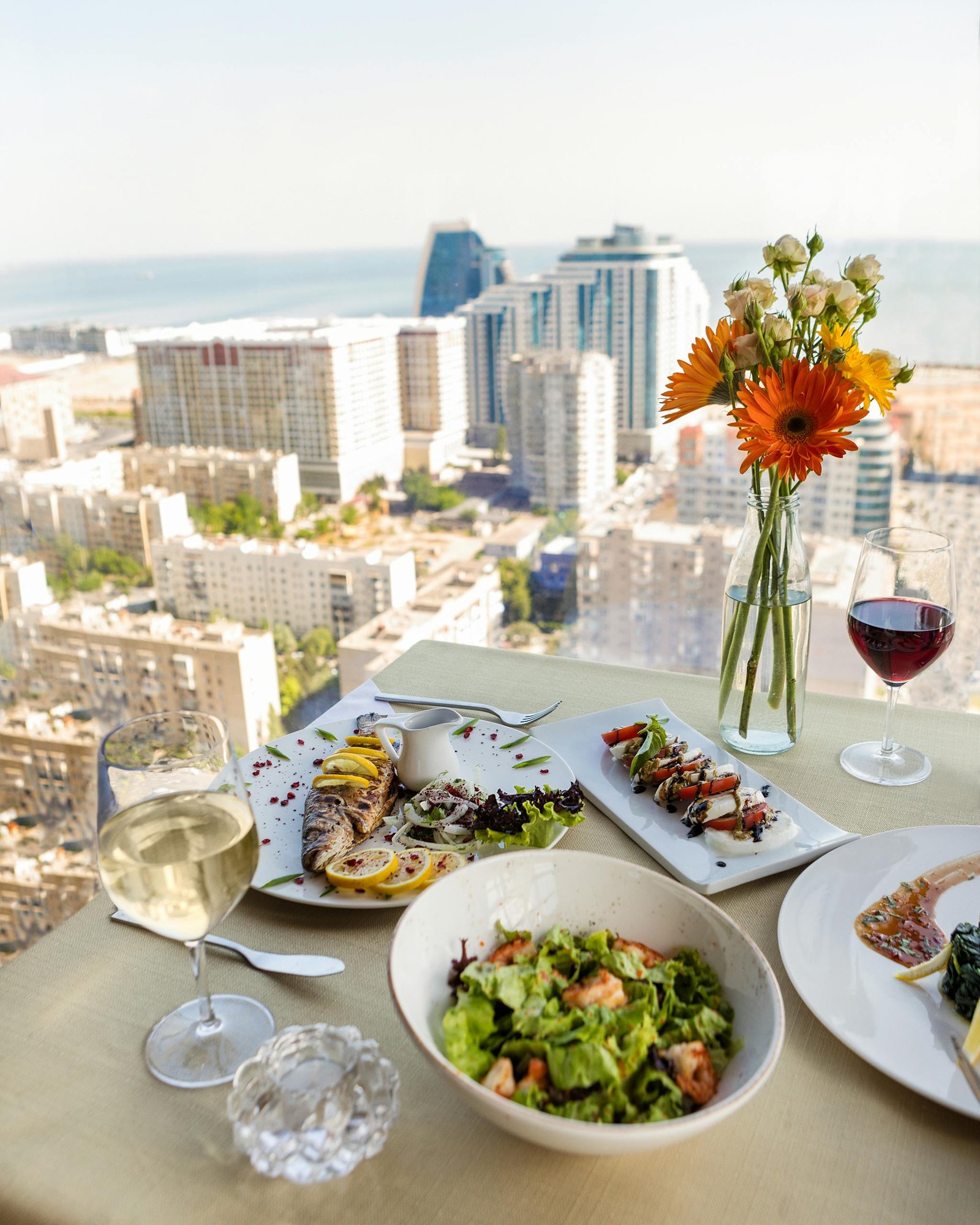 Spain Travel Guide: Things to know before travelling to Spain 11 Elegant dining table with seafood and salads overlooking Baku cityscape.
