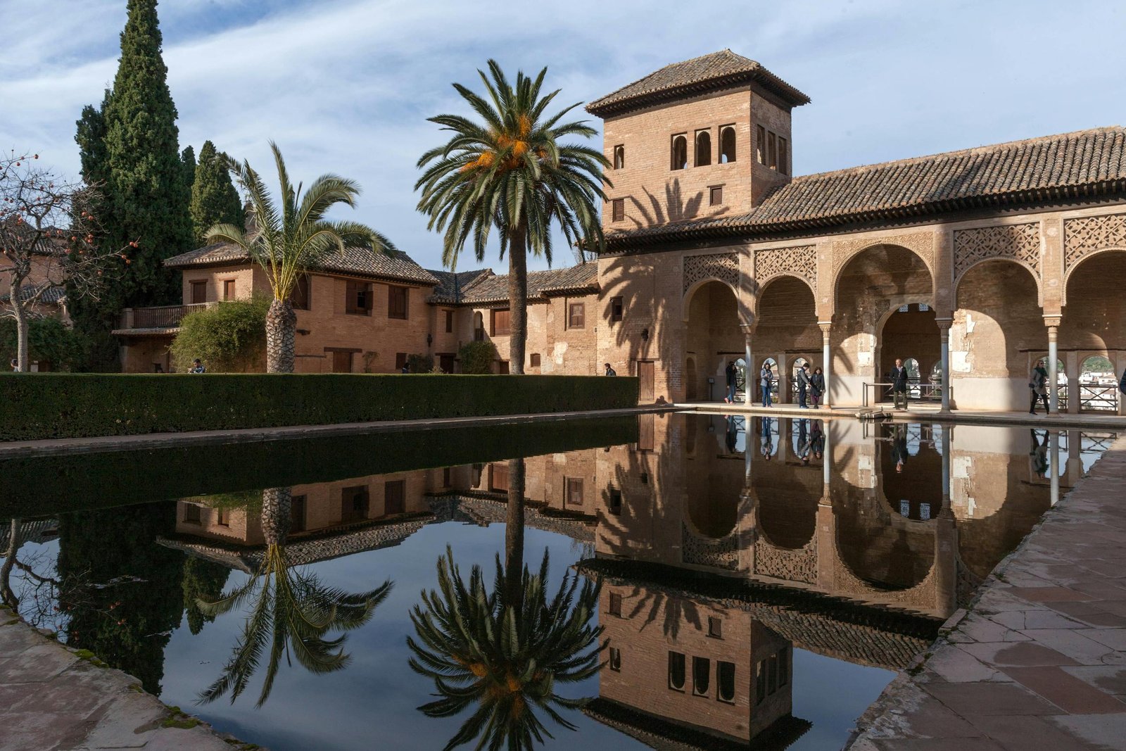 Spain Travel Guide: Things to know before travelling to Spain 7 Stunning view of the Alhambra's intricate architecture reflected in a tranquil pond.