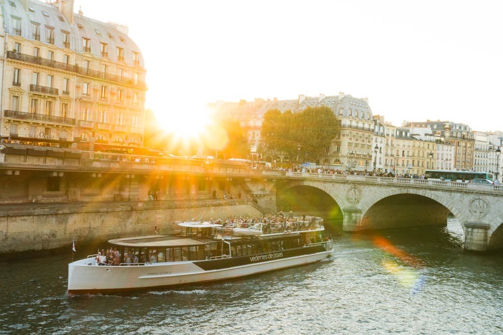 A scenic view of a river cruise boat on the Seine during sunset in Paris.