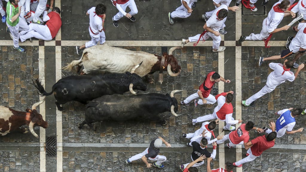 Best Time to Visit Spain: A Complete Guide to Spain's Seasons and Weather 7 Aerial view of people running with bulls during the famous festival in Spain.