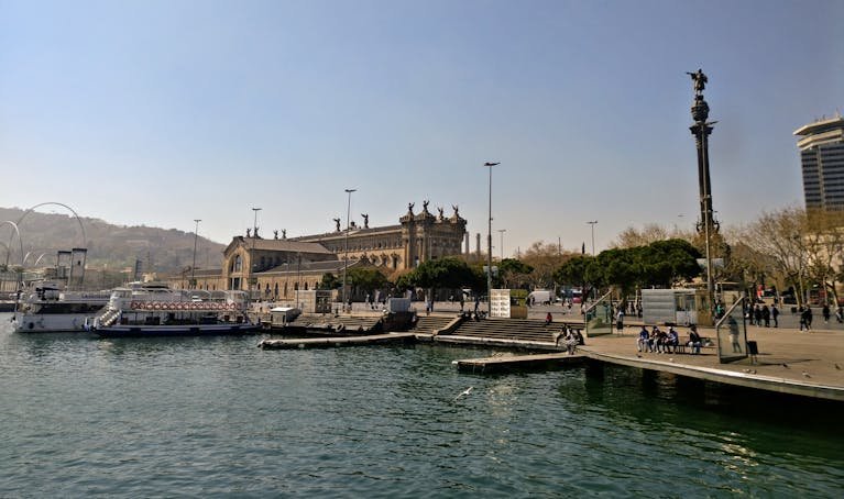 Beautiful view of Barcelona's port area with historic architecture and waterfront activity.
