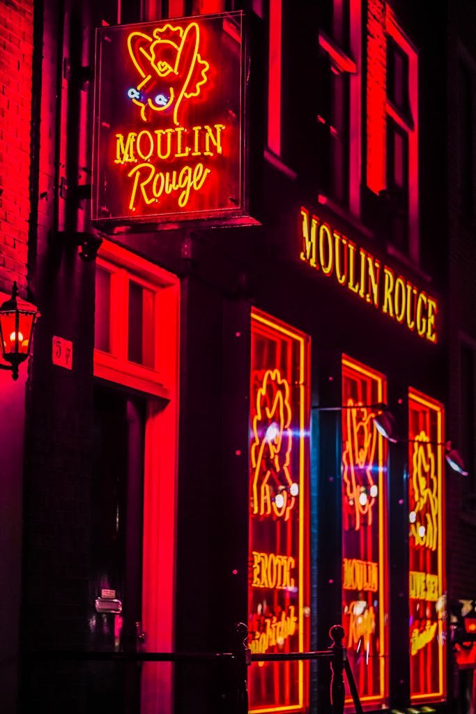 Bright neon signs of Moulin Rouge in Amsterdam capture the nightlife ambiance.