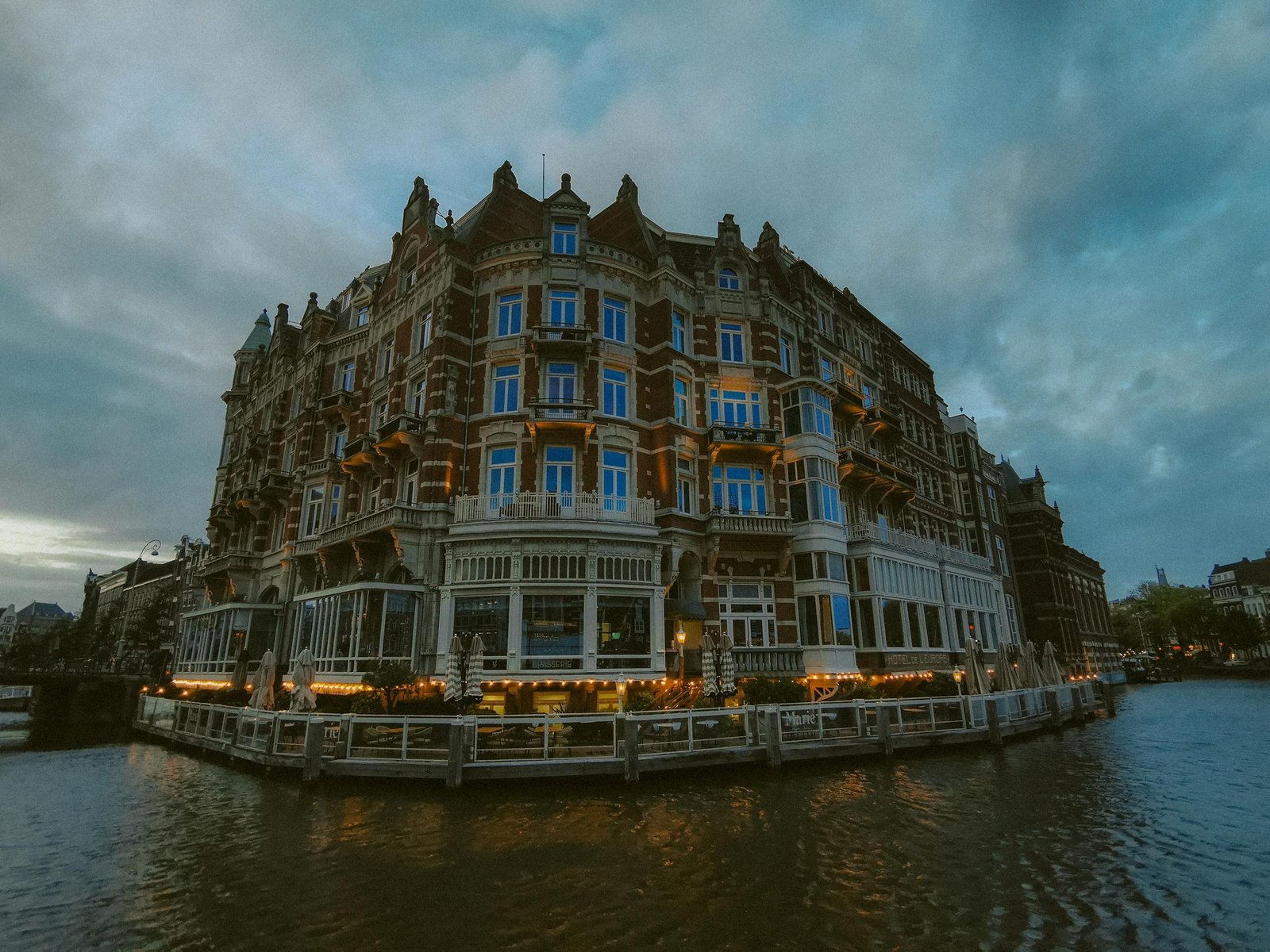 Charming historic hotel by the Amsterdam canal, captured during twilight with beautiful architectural details and reflections.