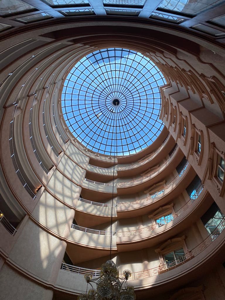 Impressive spiral atrium interior with a glass ceiling in Taif, Saudi Arabia, showcasing modern architecture.