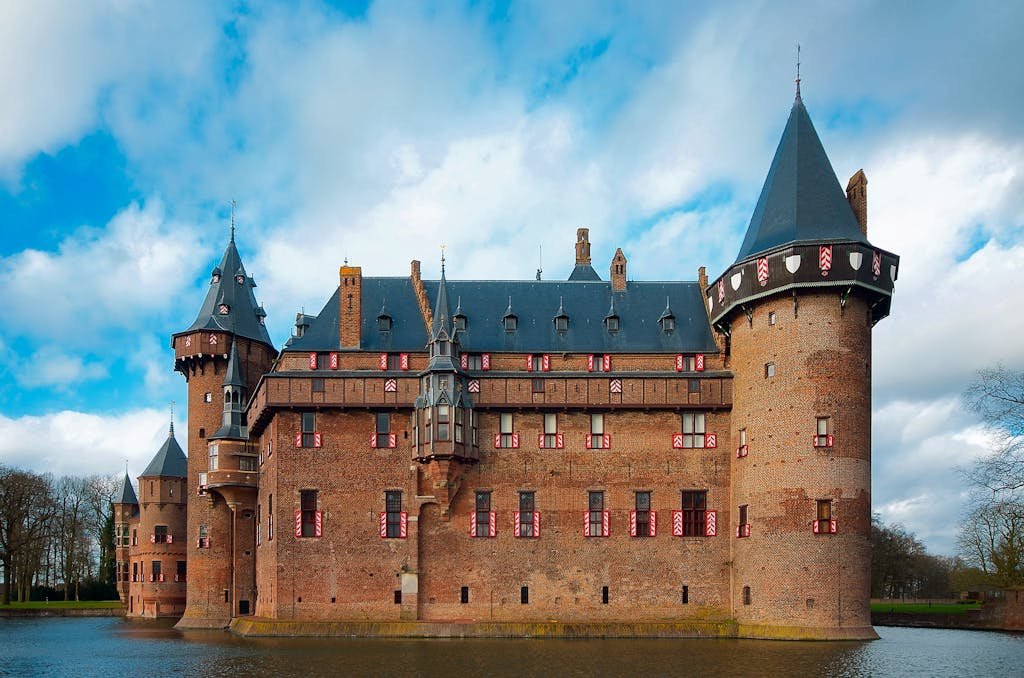Majestic Gothic De Haar Castle with a moat under a bright sky, Utrecht, Netherlands.