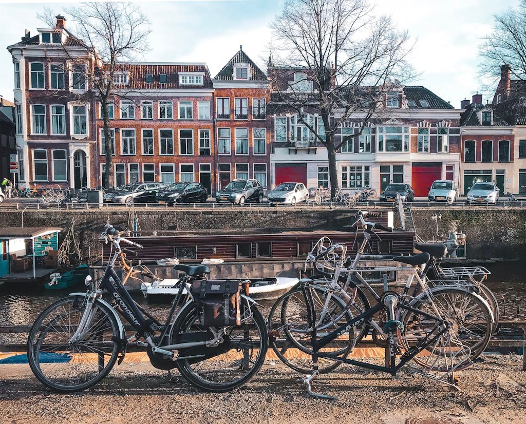 Picturesque street view of Groningen featuring bicycles, canal, and historic architecture on a sunny day.