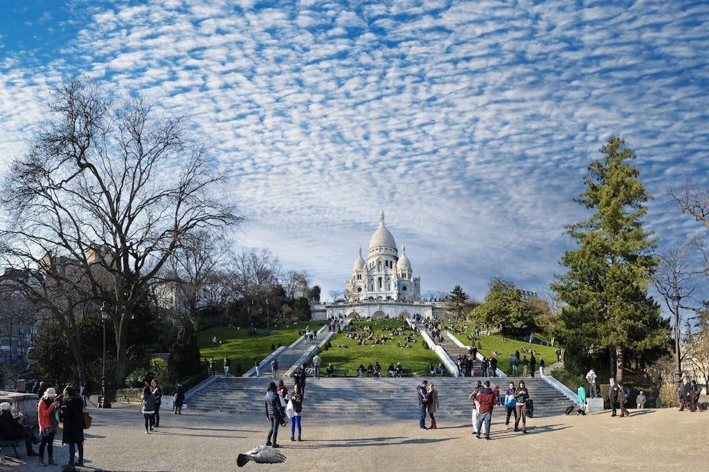 Sacre-Coeur Basilica in Paris with visitors enjoying a sunny day.
