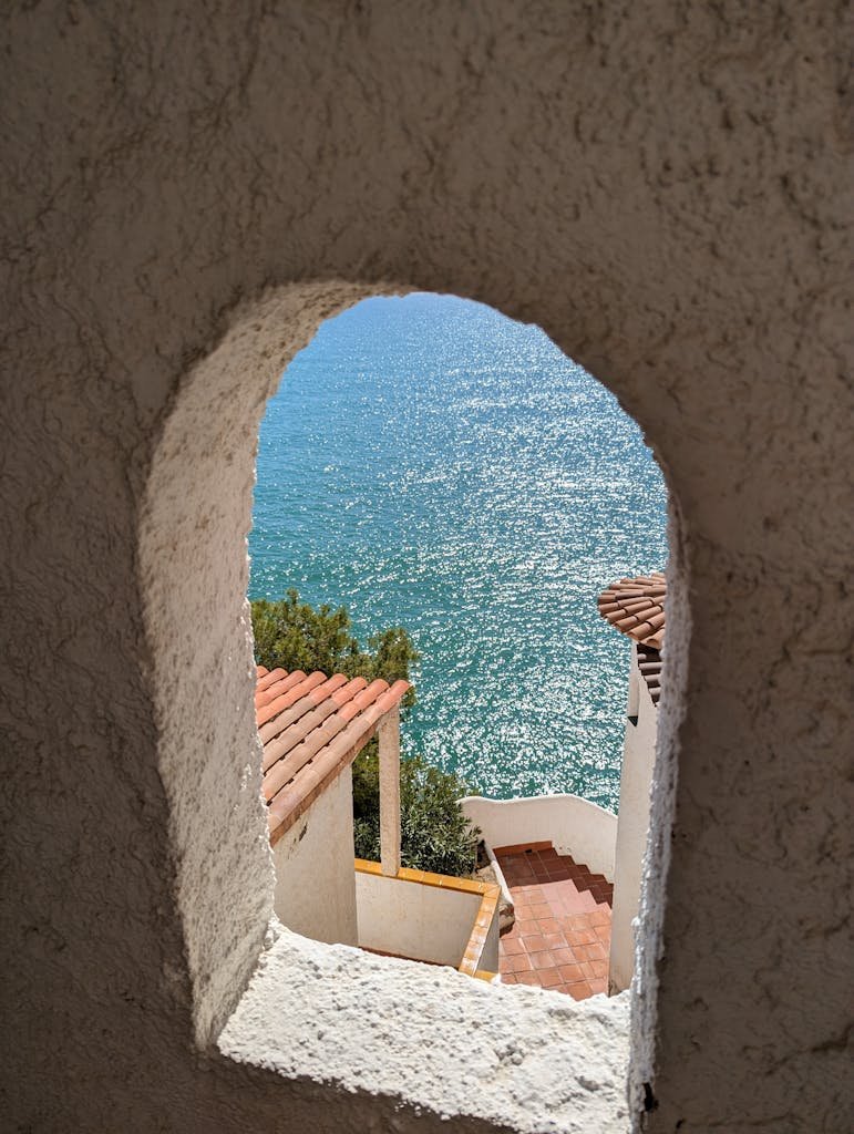 Scenic view of Mediterranean Sea through arched window in Sitges, Spain.