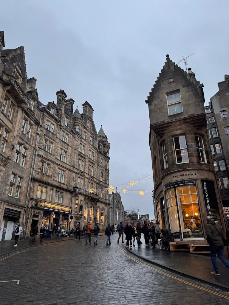45 Unique Things to Do in Edinburgh: Hidden Spots & Must-See Attractions 16 A bustling street scene in Edinburgh, Scotland featuring historic architecture and lively crowds.