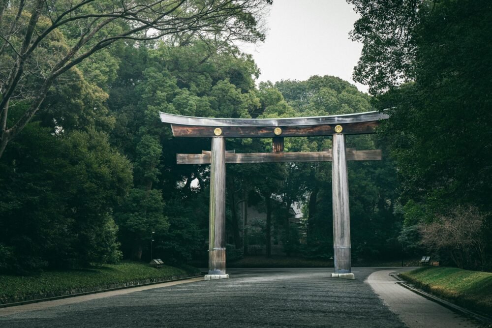 31 Best Things to Do in Tokyo, Japan 11 A tranquil scene of the Meiji Jingu Torii gate surrounded by lush green trees in Tokyo, Japan.