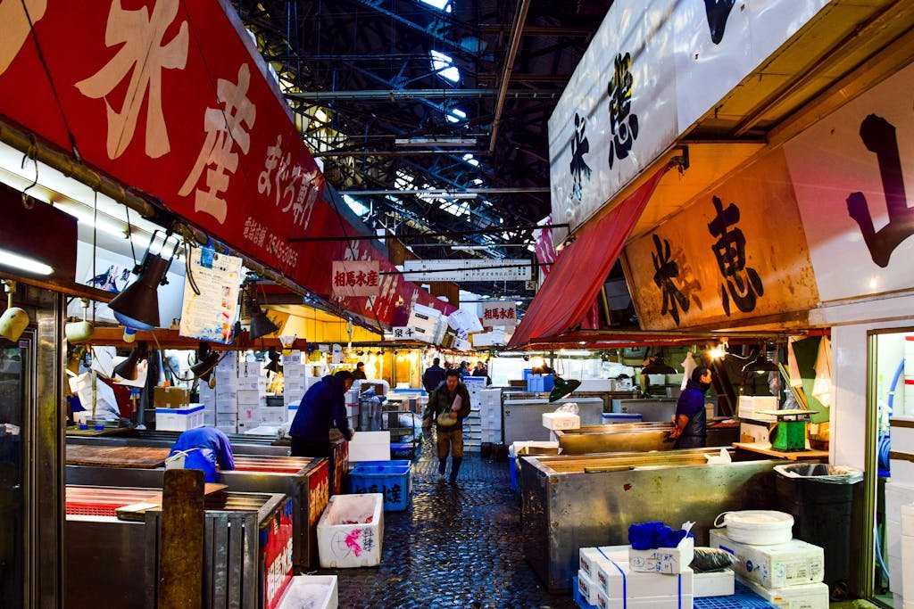 31 Best Things to Do in Tokyo, Japan 6 A vibrant scene of vendors and shoppers at Tsukiji fish market in Tokyo during nighttime.
