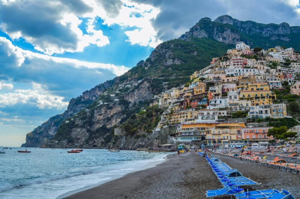 Charming seascape of Positano's colorful hillside houses against a majestic mountain backdrop.