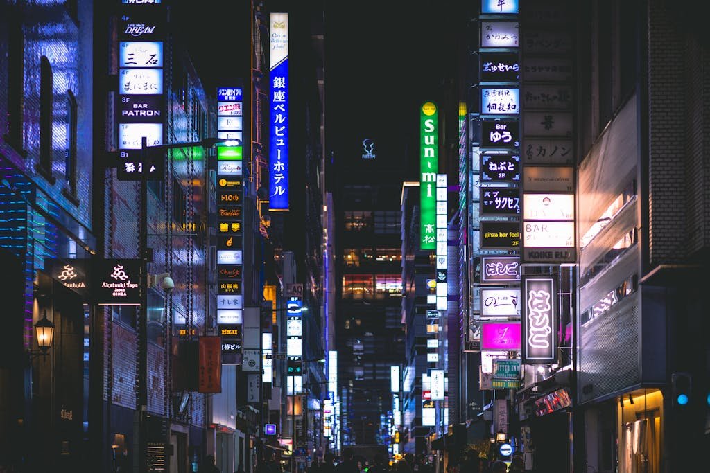 31 Best Things to Do in Tokyo, Japan 10 Colorful neon signs illuminate the bustling streets of Ginza, Tokyo at night, capturing urban nightlife.