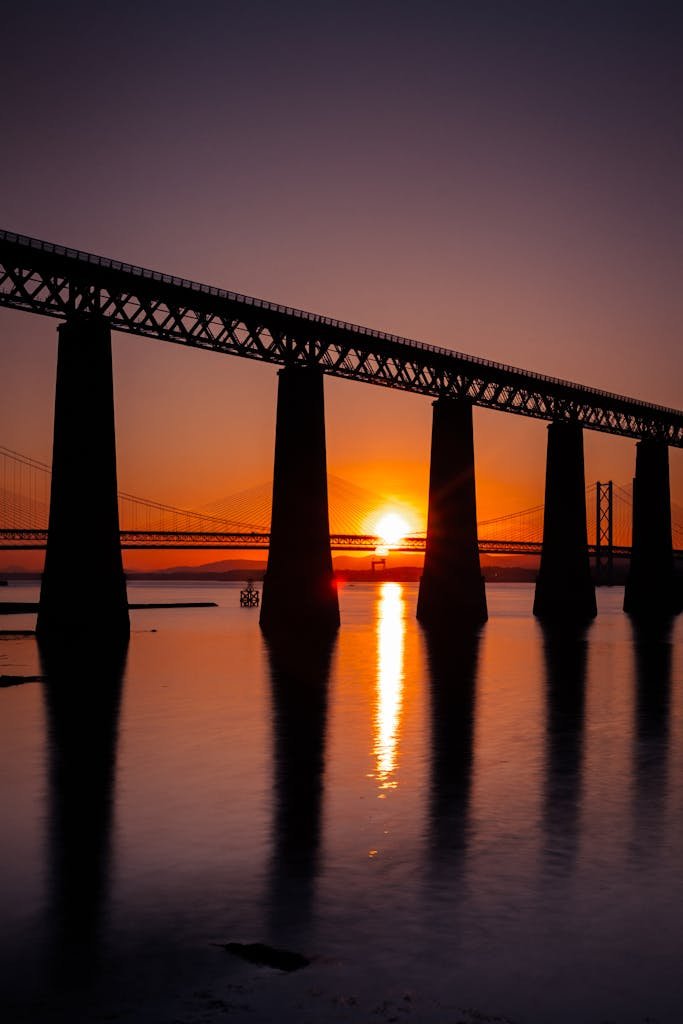 45 Unique Things to Do in Edinburgh: Hidden Spots & Must-See Attractions 34 Dramatic sunset captured over the iconic Forth Bridge in South Queensferry, Scotland.