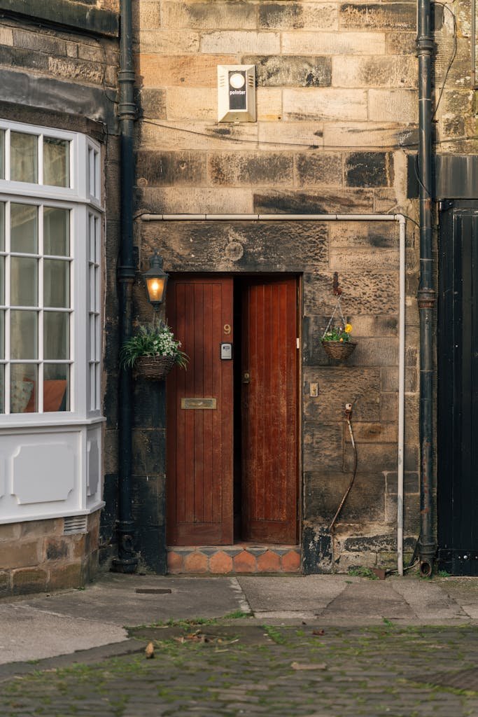 45 Unique Things to Do in Edinburgh: Hidden Spots & Must-See Attractions 21 Rustic stone wall and wooden door in historic Edinburgh alley, showcasing classic architecture.