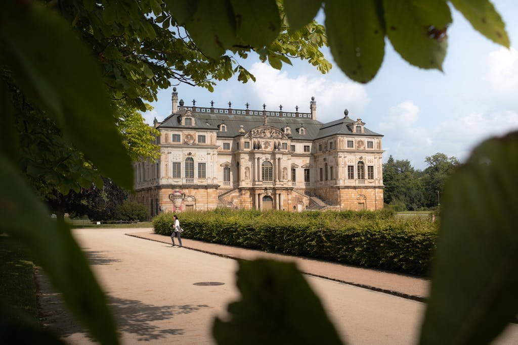 A beautiful ornate palace framed by leafy trees in Dresden's serene landscape.