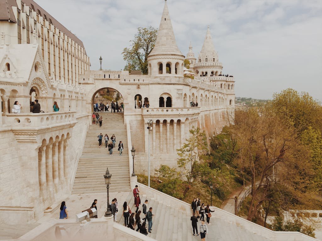 Tourists exploring the historic Fisherman's Bastion in Budapest, Hungary on a beautiful day.