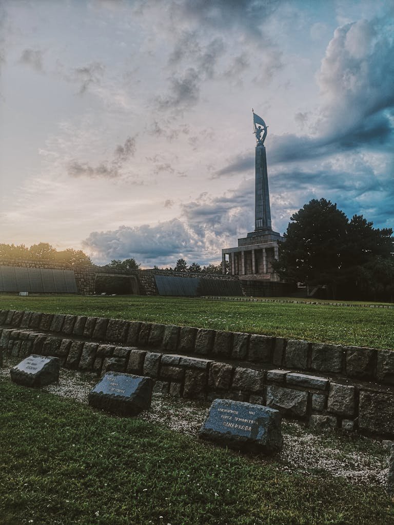 A dramatic view of Slavin Memorial in Bratislava during sunset, showcasing a serene atmosphere.