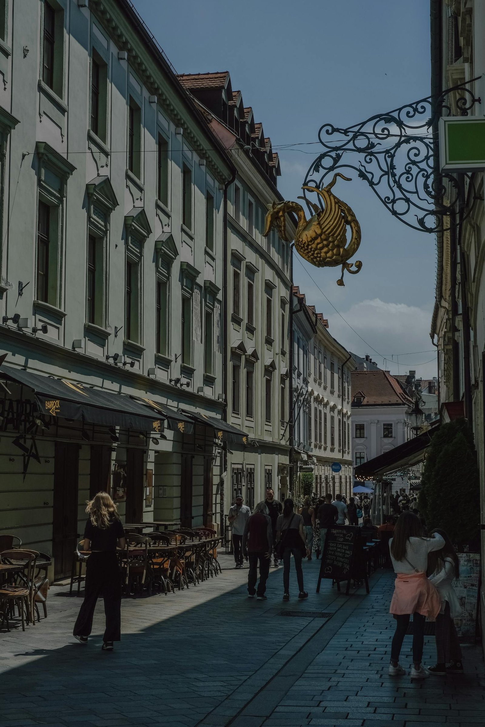 A lively street scene in historic Bratislava, revealing elegant architecture and bustling life.