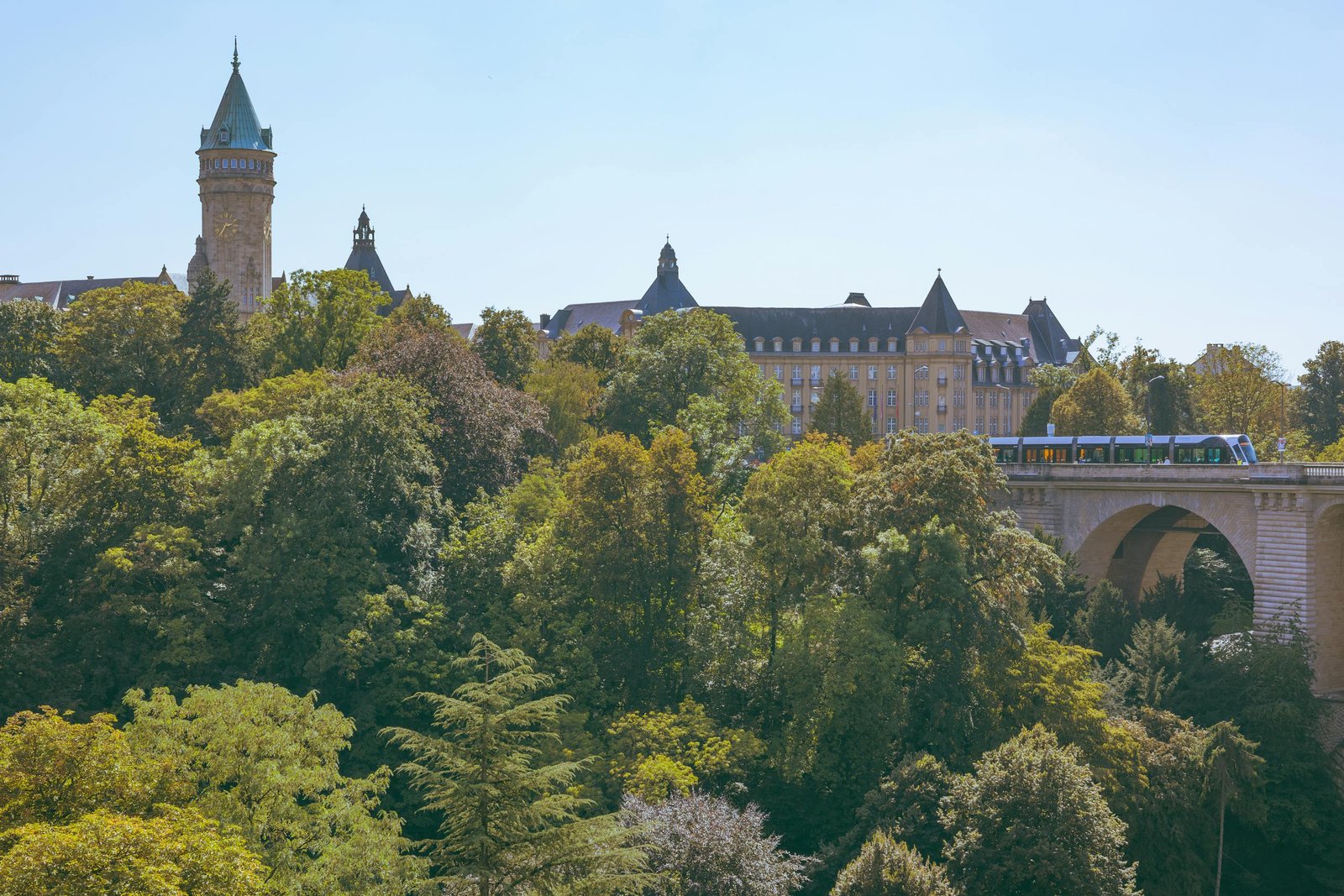 24 hours in Luxembourg Aerial view of Adolphe Bridge with lush greenery and historical buildings in Luxembourg City. Captivating urban landscape.