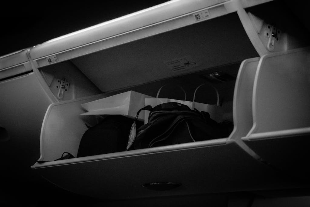 Close-up view of an airplane overhead storage compartment with Carry-on packing tips