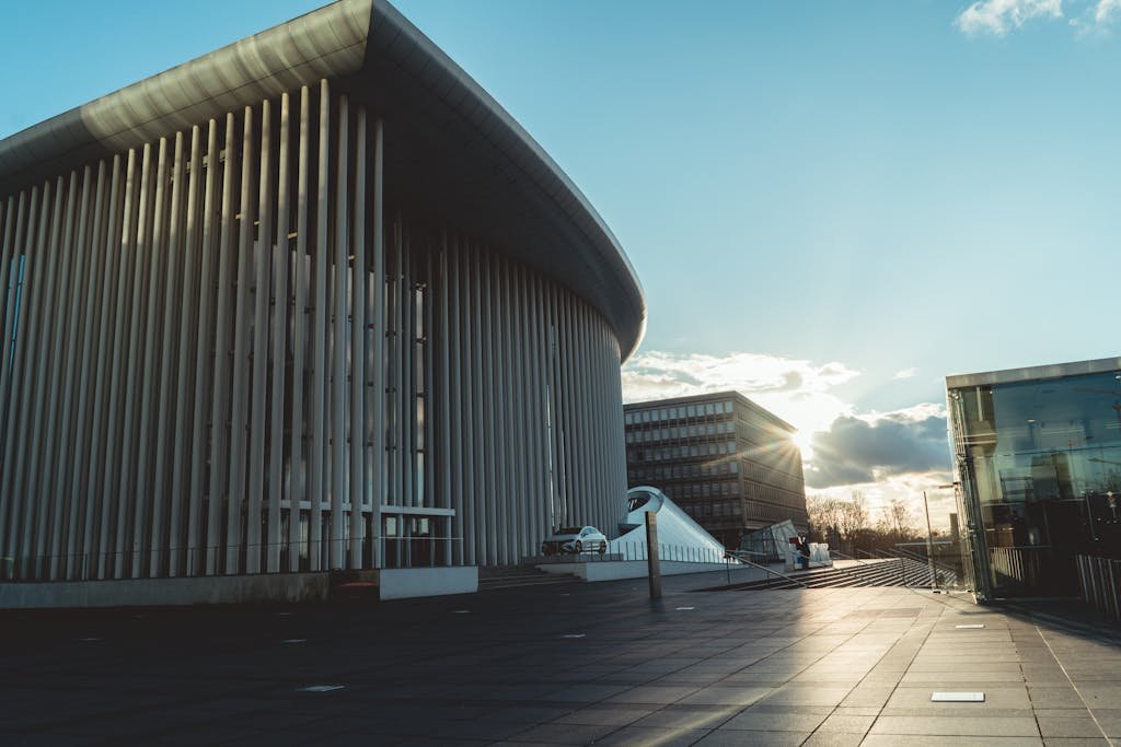 Dramatic sunset view of the Philharmonie Luxembourg's modern architecture.