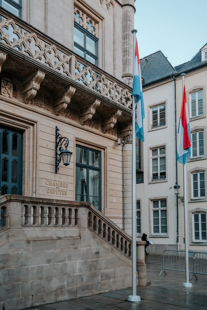 Elegant historic facade of the Chamber of Deputies in Luxembourg, featuring flags and classic architecture.