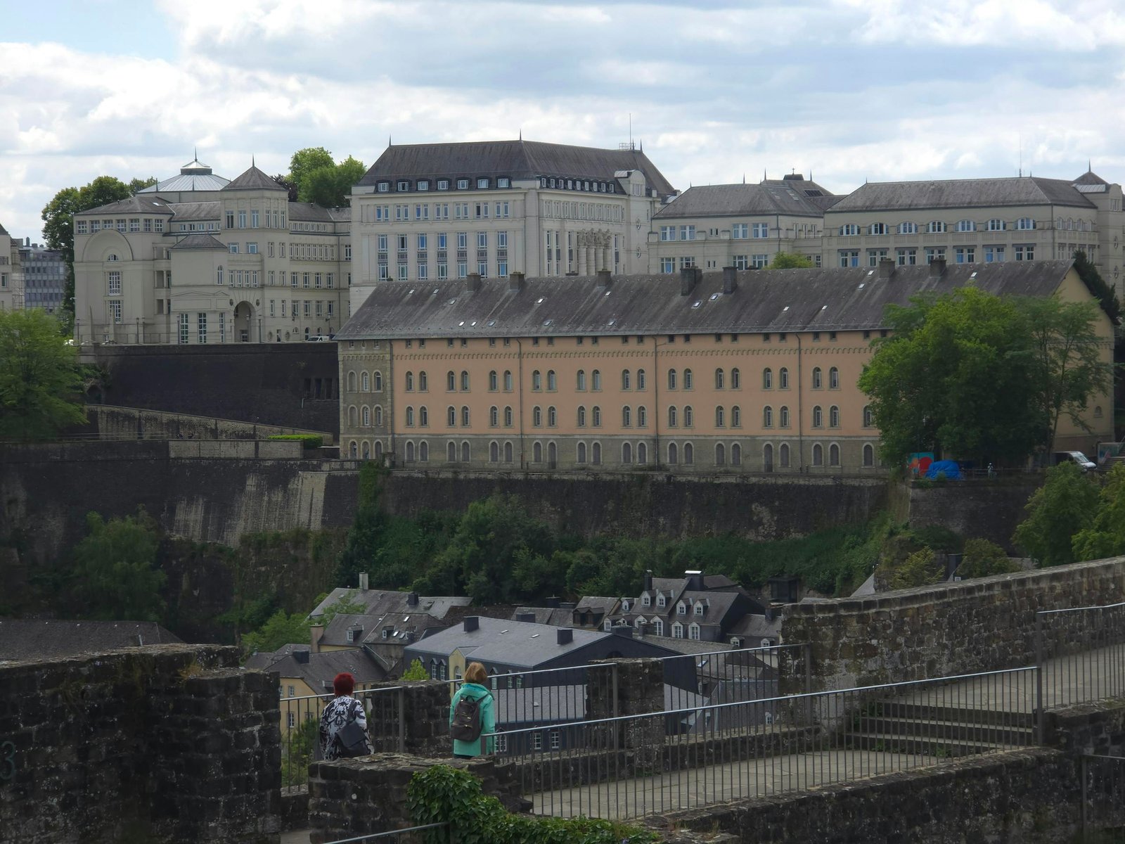 View of historic buildings and fortifications in Luxembourg City, contrasting old and new architecture.