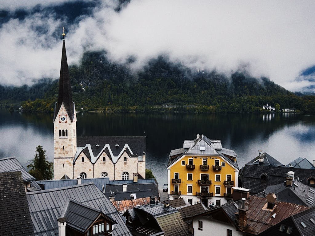 5 Days in Austria: The Perfect Austria Road Trip Itinerary 4 A picturesque view of Hallstatt's iconic church spire and colorful buildings by a serene lake.