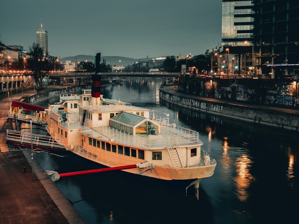 5 Days in Austria: The Perfect Austria Road Trip Itinerary 22 A serene night scene of a docked boat on the Donaukanal in Vienna, Austria, showcasing urban reflections.