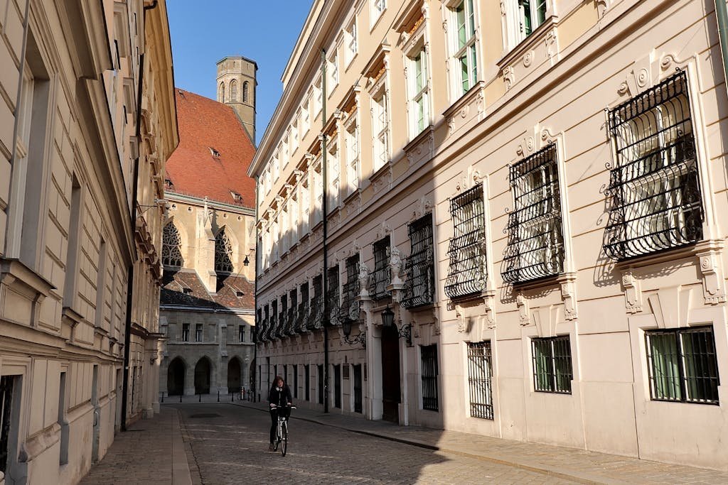 5 Days in Austria: The Perfect Austria Road Trip Itinerary 10 Beautiful narrow street in Vienna with historic buildings and a cyclist.
