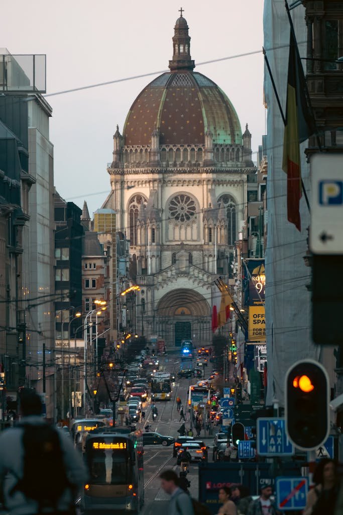 15 Best Things To Do In Brussels Belgium: Tips for first time visitors 7 Busy street in Brussels with Church of St. John and St. Stephen in the backdrop.