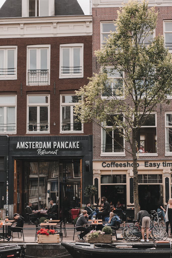 Your Complete Dutch Food Guide: What to Eat in Amsterdam and Beyond 16 Charming daytime view of a lively Amsterdam street with cafes and outdoor seating.