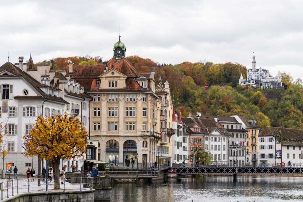 How to Spend the Perfect 5 Days in Switzerland Itinerary? 6 Charming view of Lucerne's waterfront with autumn foliage and historic architecture.