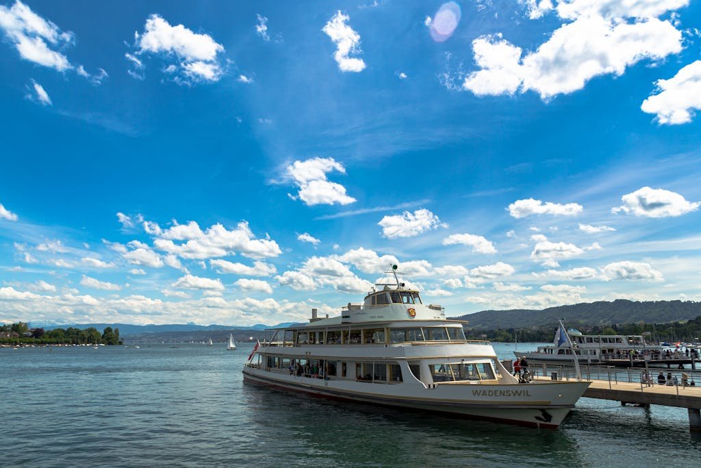 How to Spend the Perfect 5 Days in Switzerland Itinerary? 18 Ferry docked at Lake Zurich with beautiful blue sky and white clouds in Switzerland.