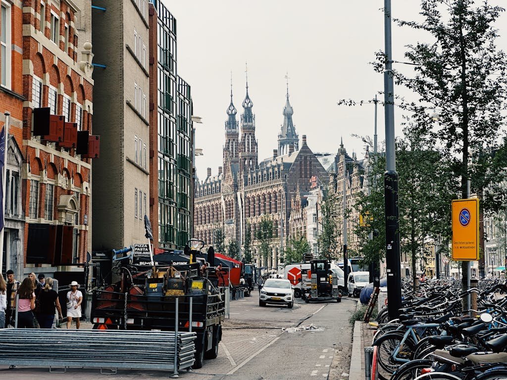 9 Ways of Getting Around Amsterdam Like a Local 8 Lively street scene in Amsterdam featuring iconic historical architecture and bustling urban life.