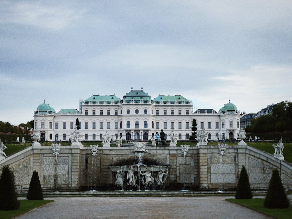 5 Days in Austria: The Perfect Austria Road Trip Itinerary 12 Majestic Belvedere Palace in Vienna with ornate garden and fountain under a cloudy sky.