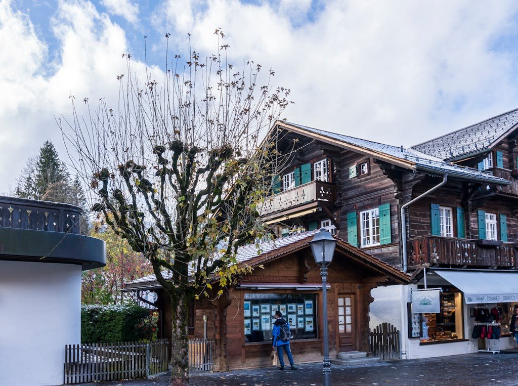 How to Spend the Perfect 5 Days in Switzerland Itinerary? 15 Rustic chalet-style architecture in the picturesque Saanen village, Switzerland, under a bright sky.