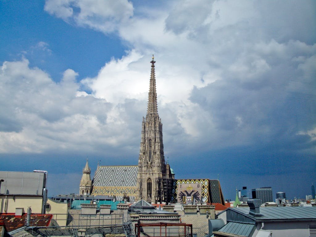 5 Days in Austria: The Perfect Austria Road Trip Itinerary 7 St. Stephen's Cathedral against a vibrant Vienna skyline under dramatic clouds.