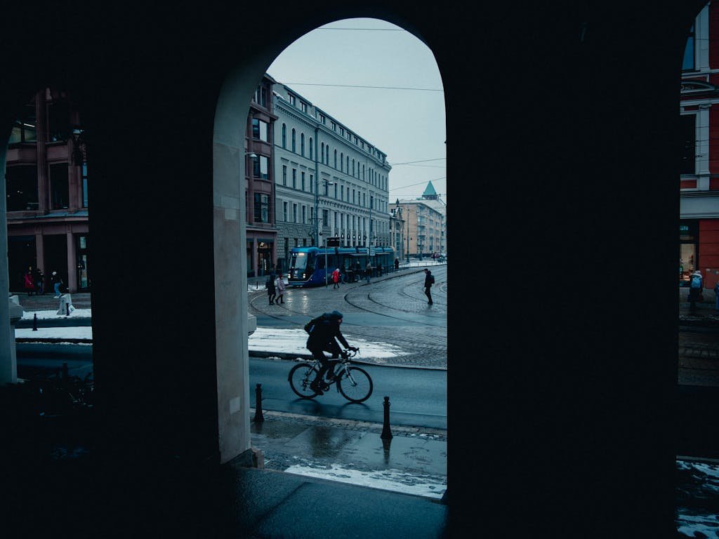 15 Best Things To Do In Brussels Belgium: Tips for first time visitors 15 Street scene capturing a cyclist passing through an arch in a European city during winter.