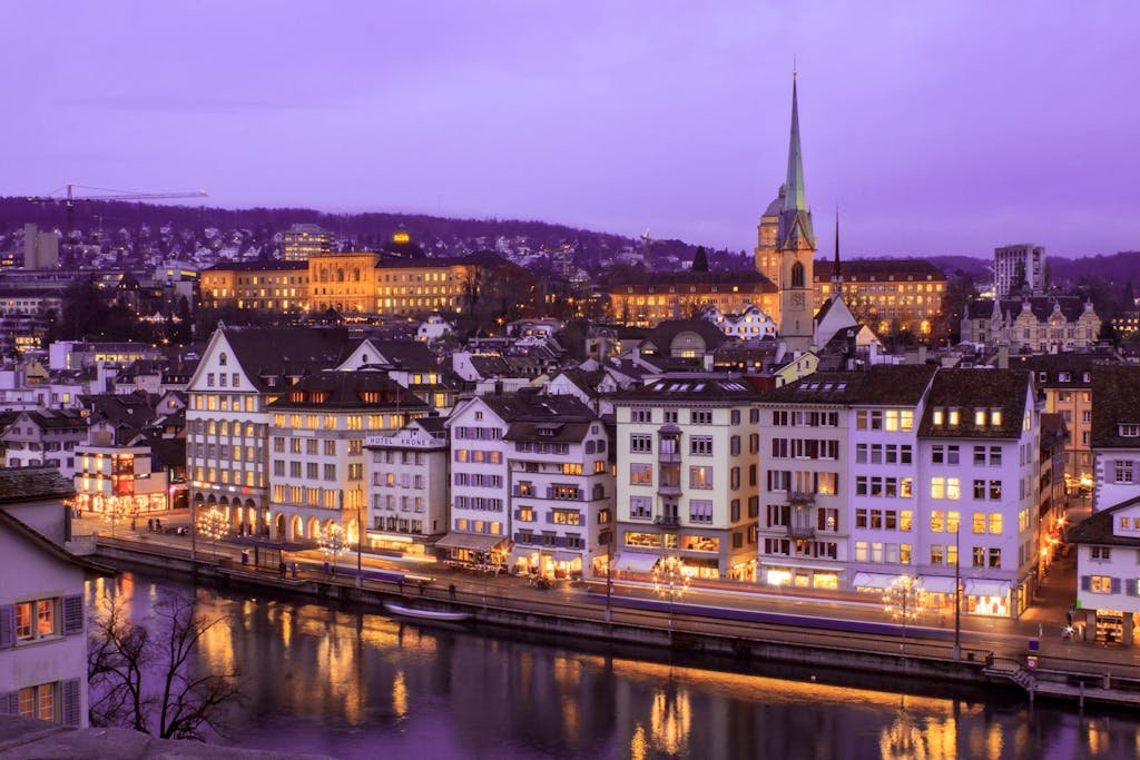 How to Spend the Perfect 5 Days in Switzerland Itinerary? 3 Stunning cityscape of Zurich at twilight with illuminated buildings and a serene river view.