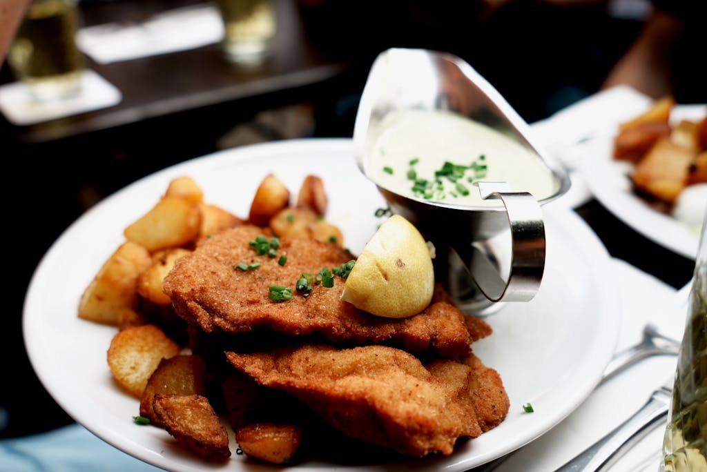 5 Days in Austria: The Perfect Austria Road Trip Itinerary 19 Tasty schnitzel served with roasted potatoes and lemon, complemented by creamy sauce.