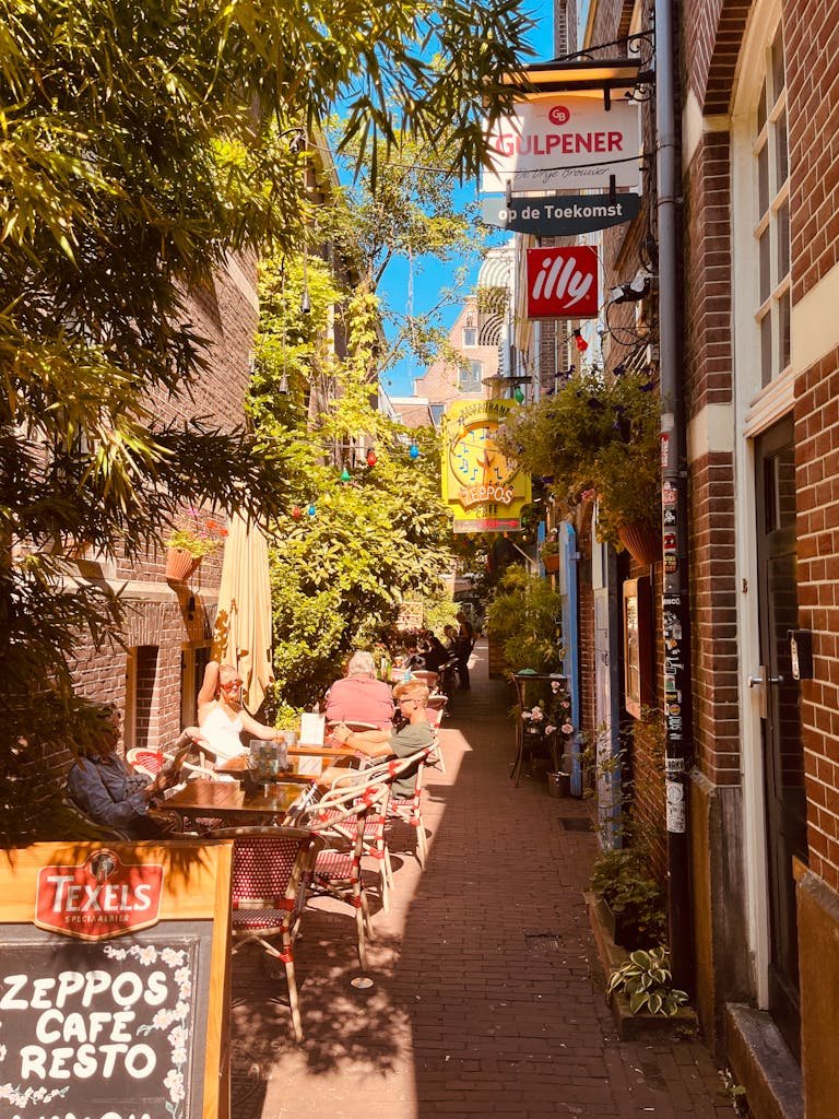 Your Complete Dutch Food Guide: What to Eat in Amsterdam and Beyond 15 Vibrant European alley with outdoor café seating on a sunny day.