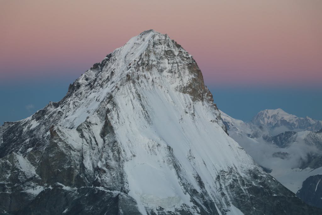 A breathtaking sunrise over a snow-capped mountain in serene winter scenery.