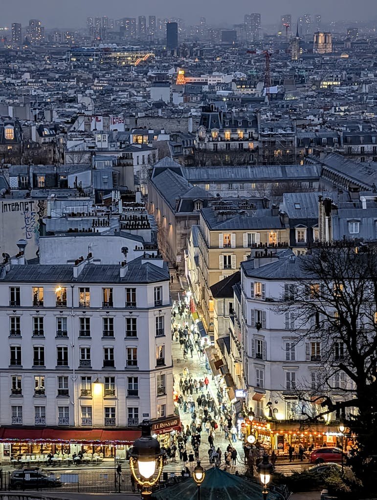 41 best Things to Do in Paris: Iconic Sights to Hidden Gems 18 A bustling evening view of Montmartre's lively streets and iconic Parisian rooftops.