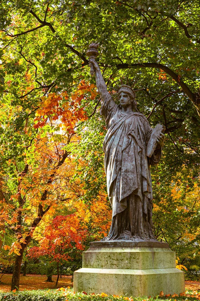 41 best Things to Do in Paris: Iconic Sights to Hidden Gems 12 A statue surrounded by vibrant autumn foliage in the Luxembourg Gardens, Paris.